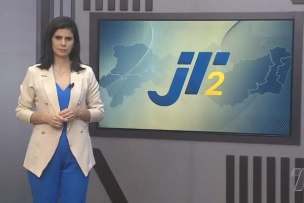 Eliane Nóbrega em frente a tela com o logo do Jornal da Tribuna 2ª edição na afiliada da Band