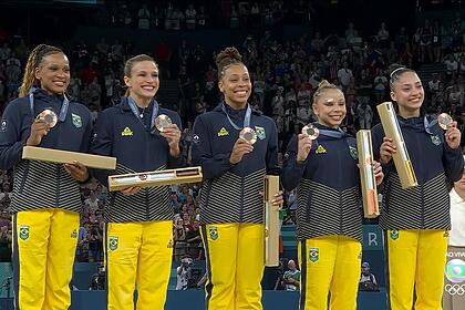 Rebeca Andrade, Jade Barbosa, Lorrane Oliveira, Flávia Saraiva e Julia Soares mostram a medalha de bronze no peito na Olimpíada de Paris 2024