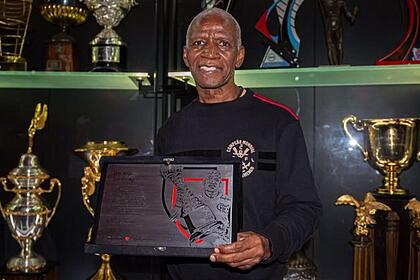 Adílio, segurando uma placa, em trecho de homenagem do Flamengo