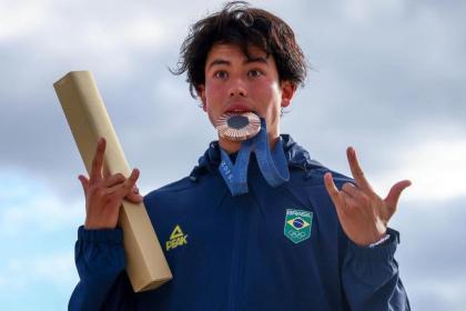 Augusto Akio com a medalha na boca na Olimpíada 2024