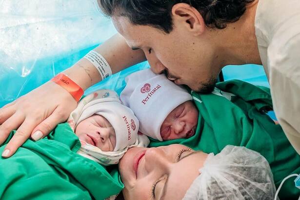 Pedro ao lado da esposa, com as duas filhas gêmeas após o nascimento