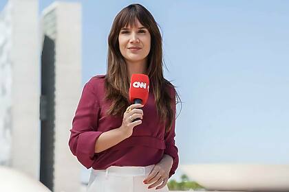 Renata Varandas segura microfone da CNN Brasil em frente a Câmara dos Deputados