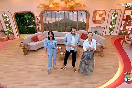 Michelle Barros, Paulo Mathias e Regina Volpato em pé no cenário do Chega Mais