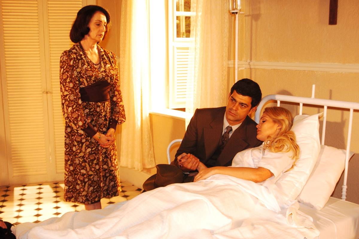 Débora (Ana Lúcia Torre) observa Rafael (Eduardo Moscovis) e Cristina (Flávia Alessandra) no hospital em cena de Alma Gêmea
