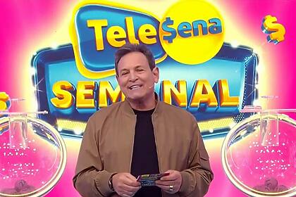 Luiz Ricardo Sorrindo no cenário da Tele Sena Semanal, edição 22, que está na cor rosa