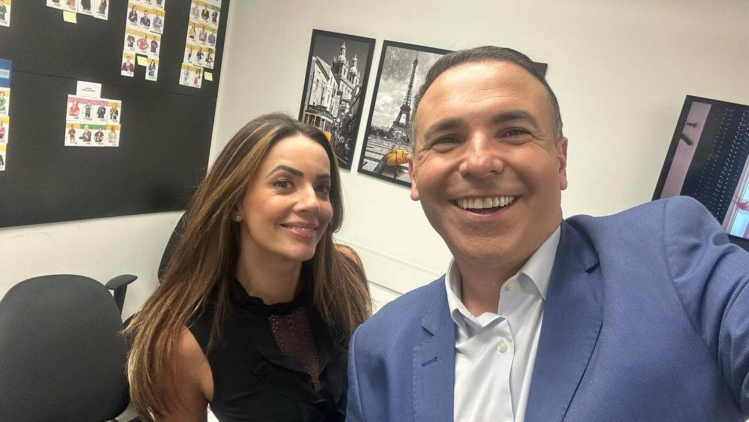 Paloma Tocci e Reinaldo Gottino sorrindo nos bastidores da RECORD