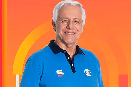 Milton Leite com o uniforme da TV Globo sorrindo em um fundo laranja