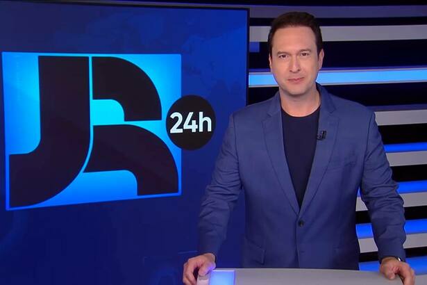 Eduardo Ribeiro de terno azul apresentando o Jornal da Record 24h