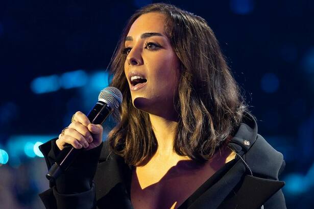 Lara Silva cantando no palco do Domingão