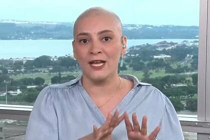 Larissa Rodrigues, careca e com uma blusa azul, em trecho de entrada ao vivo na CNN Brasil