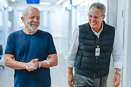 Presidente Lula sorrindo e caminhando ao lado do cirurgião Marcos Stavale no hospital