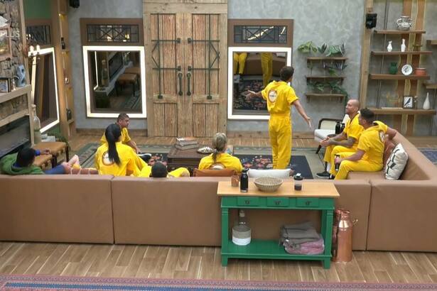 Peões vestidos de amarelo escutam sinal de recreio na sala de A Fazenda 16
