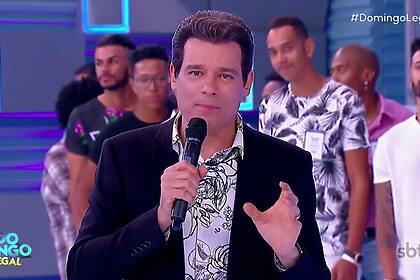 Celso Portiolli de terno preto apresentando o Xaveco no Domingo Legal
