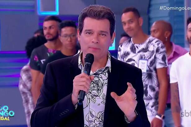Celso Portiolli de terno preto apresentando o Xaveco no Domingo Legal