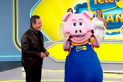 Luiz Ricardo sorrindo ao lado do porquinho no cenário da Tele Sena Semanal