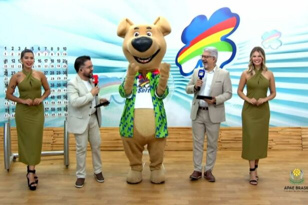 Luck, o mascote de pelúcia do Pernambuco dá Sorte, ao lado dos apresentadores no centro do palco