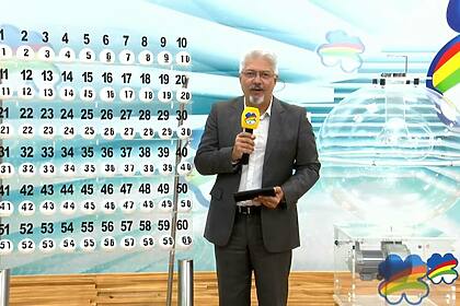 Apresentador Rhaldney Santos ao lado do expositor das bolas do Pernambuco da Sorte