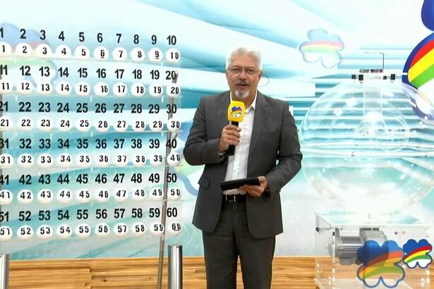 Apresentador Rhaldney Santos ao lado do expositor das bolas do Pernambuco da Sorte