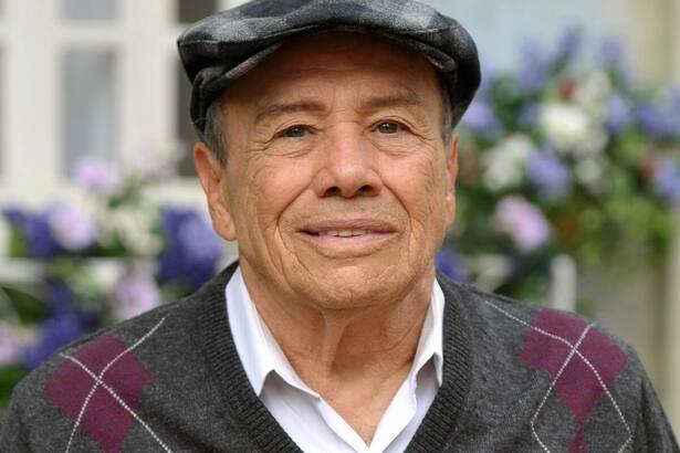 Stênio Garcia de boina e casaco cinza nos bastidores da novela dda Globo