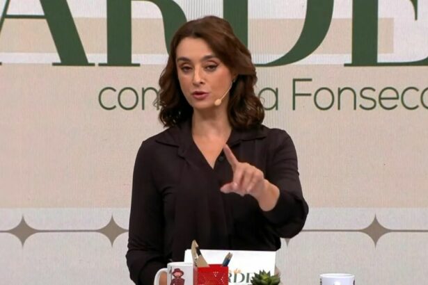 Catia Fonseca, vestindo uma blusa social prata, na bancada do Melhor da Tarde