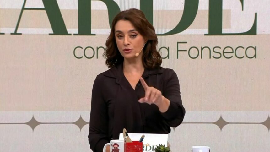 Catia Fonseca, vestindo uma blusa social prata, na bancada do Melhor da Tarde