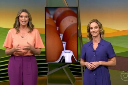 Cristina Vieira de blusa marrom e Helen Martins de roupa lilás, na frente do telão do Globo Rural,