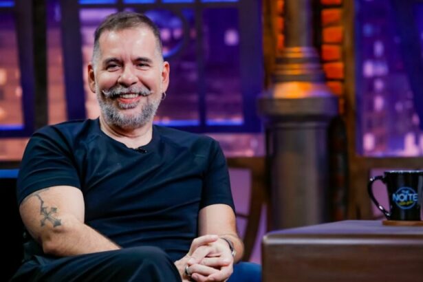Leandro Hassum sentado na poltrona do estúdio do The Noite
