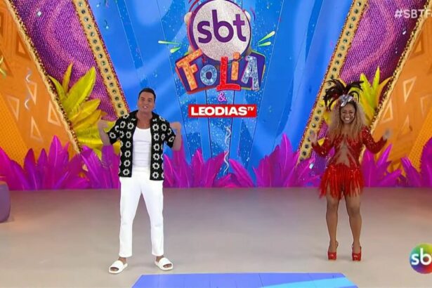 Leo Dias veste preto e branco, enquanto Caríucha vem com uma roupa vermelho