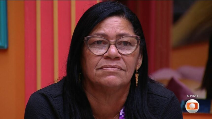Delma de óculos de grau na sala do BBB 25 olhando para o telão após dá imunidade para Eva