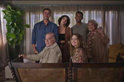 Tony Ramos, Cláudia Abreu e outros atores em uma sala, cenário de Dona de Mim, olhando para a protagonista da novela da sete Dona de Mim. todos estão sorrindo