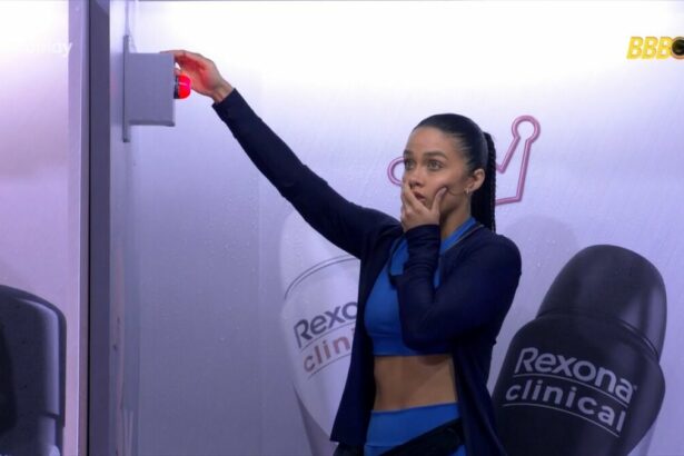 Eva aperta o botão que fica vermelho. Ela está espantada com a mão na boca na cabine da Prova do Líder de Resitência