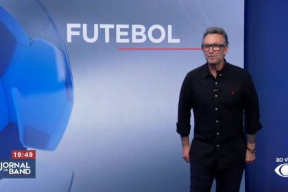 Craque Neto em frente ao telão do Jornal da Band com o logo do Futebol