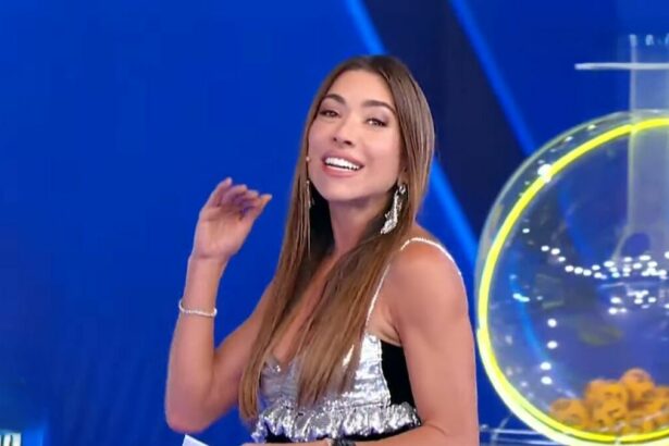 Patricia Abravanel, de roupa branco com preto, no cenário do sorteio da Tele Sena de Páscoa 2025