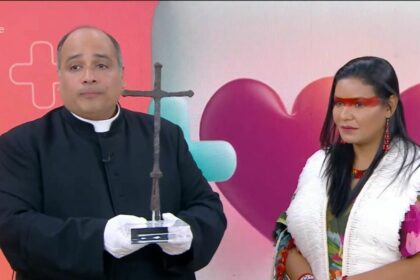 Padre omar segurando uma cruz no estúdio do mais você