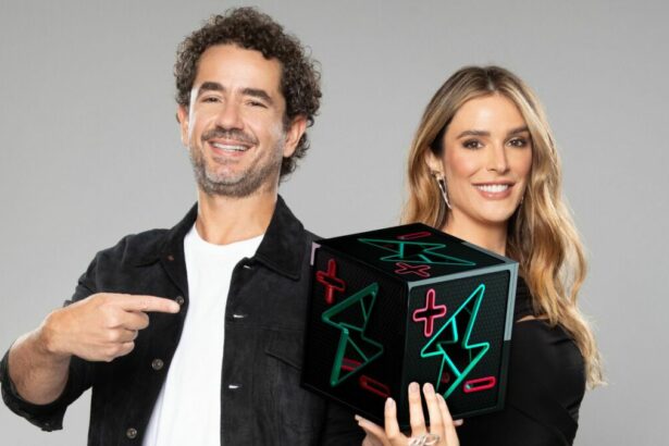Rafa Brites e Felipe Andreoli, com o dado do Power Couple em mãos, em foto posada