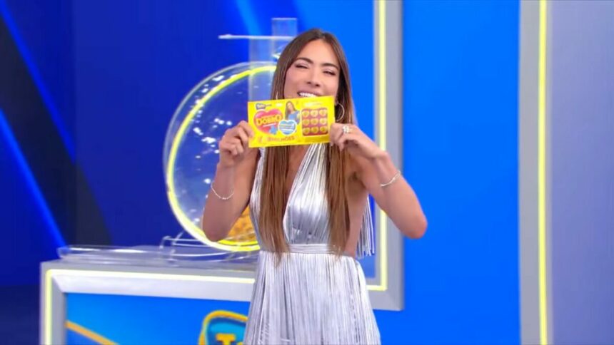 Patricia Abravanel sorrindo e segurando o bilhete do segundo sorteio da Tele Sena de Mães 2025