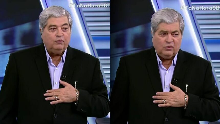 Datena usa terno preto e camisa clara lilá no cenário do Tá na Hora no SBT