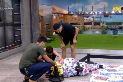 Diego hypolito, vestido de rei, caído no chão do castigo do monstro do bbb 25. Vinicius, guilherme e vitória strada ao lado tentando ajudar