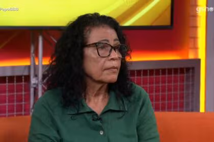 Vilma de roupa verde olhando com semblante sério para os apresentadores do bate papo bbb 25