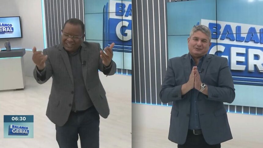 Evenilson Santana de terno preto e chamando os telespectadores do Balanço Geral Manhã. Ele está sorridente. Ao lado, o apresentador Gernand Lopes vestindo terno cinza claro e juntando as mãos em sinal de agradecimento pela audiência do Balanço Geral PE
