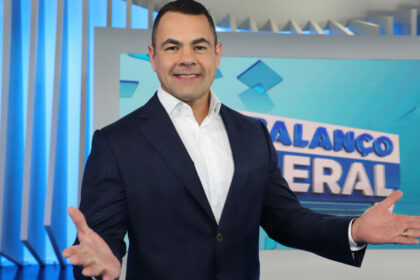 Tino Junior com os braços abertos e feliz no cenário do Balanço Geral RJ