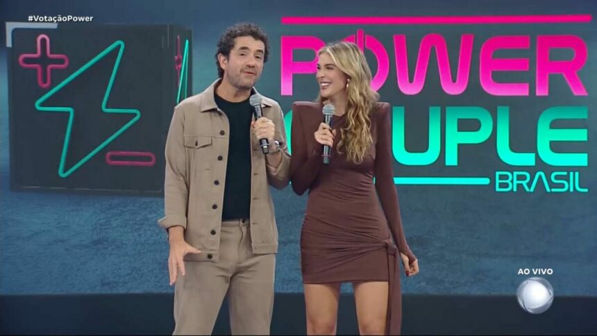 Felipe Andreoli sorrir ao lado de Rafa Brites no palco do Power Couple Brasil 7