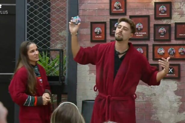 Nat e Eike em frente ao quadro da divisão de quartos no Power Couple Brasil 7