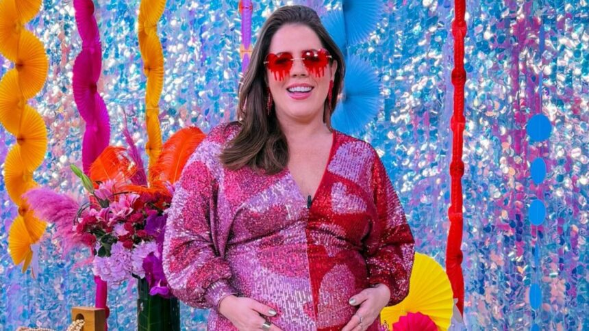 Tati Machado com a mão na barriga de grávida