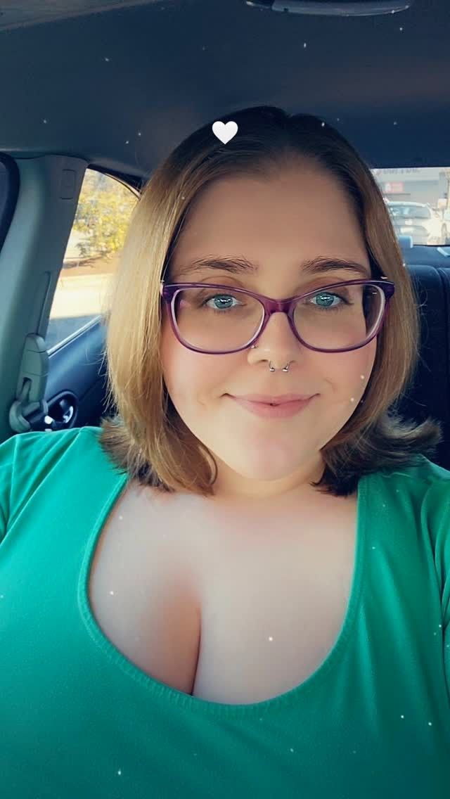 Selfie de Tiffany, que usa óculos e sorrir dentro de um carro. Ela está de blusa verde e cabelos mais curtos
