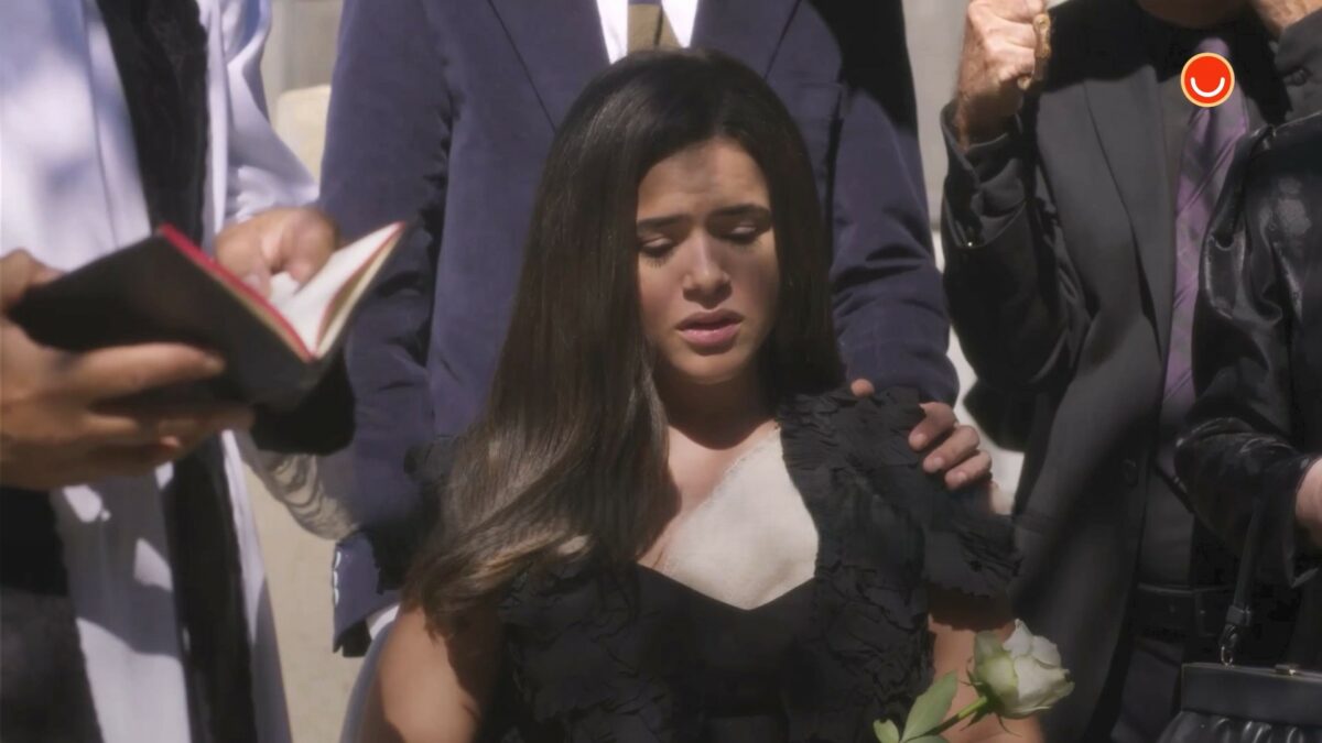 Bia chora, vestida de preto, em cena do enterro de sua mãe Valéria