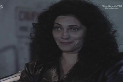 Fernanda sorrindo em frente ao local do cativeiro em cena de Cara e Coroa