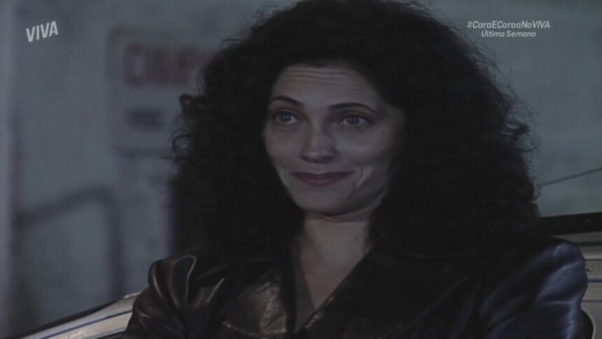 Fernanda sorrindo em frente ao local do cativeiro em cena de Cara e Coroa