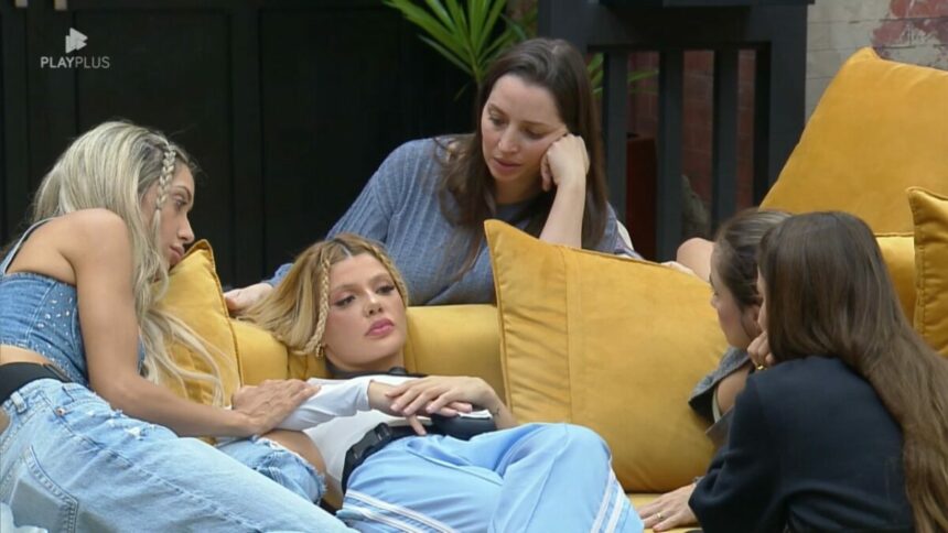 Giovanna deitada no sofá do Power Couple Brasil 7 ao lado de Carol e Tali