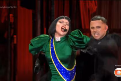 Lady Gaga canta com um vestido verde e azul e amarelo